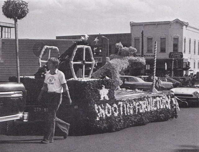 The Senior float, passing by Guisinger's Music shop on the Fayetteville square, shows a bulldog being catapulted out of a cannon toward a goal post with the theme: "Shootin' for a Victory."