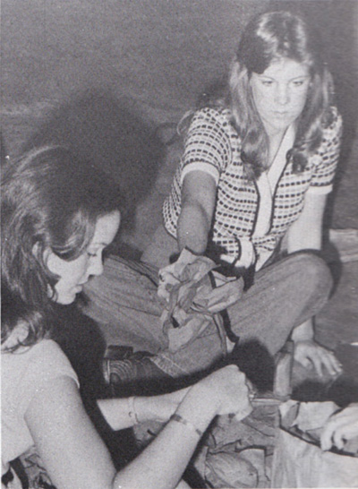 Pam Meinecke and Theresa Smith cut crepe paper for the senior float.